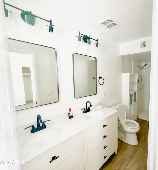 bathroom featuring hardwood / wood-style floors, vanity, toilet, and walk in shower