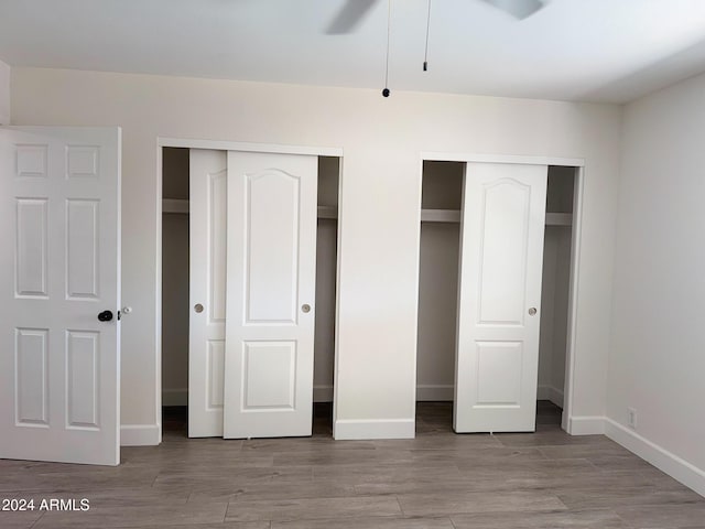 1737 N Trevor Dr, Mesa, AZ 85201 - unfurnished bedroom featuring multiple closets, baseboards, and wood finished floors