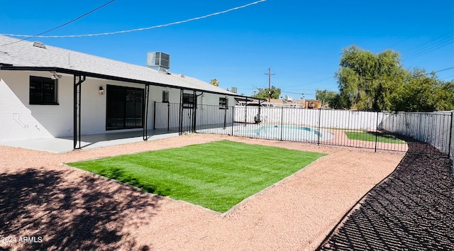 view of yard with a fenced in pool, a patio, and central AC unit