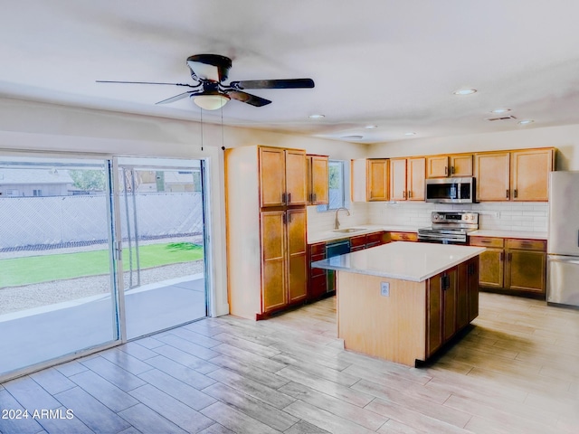 kitchen featuring light hardwood / wood-style floors, a center island, stainless steel appliances, and sink