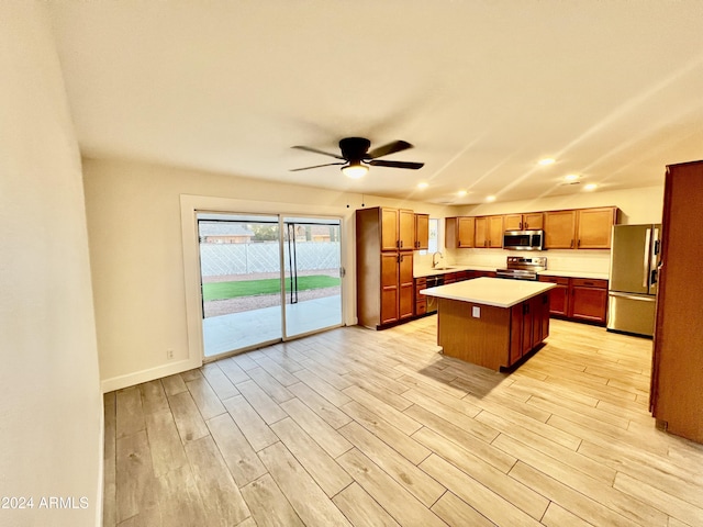 1737 N Trevor Dr, Mesa, AZ 85201 - kitchen with appliances with stainless steel finishes, light wood finished floors, light countertops, a kitchen island, and ceiling fan
