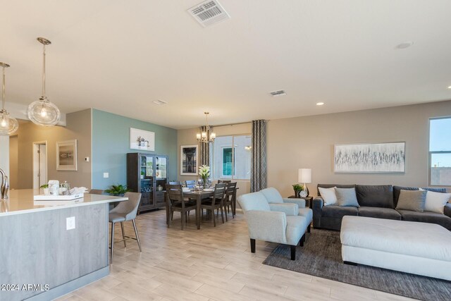 living area with a chandelier, recessed lighting, visible vents, and light wood-style flooring