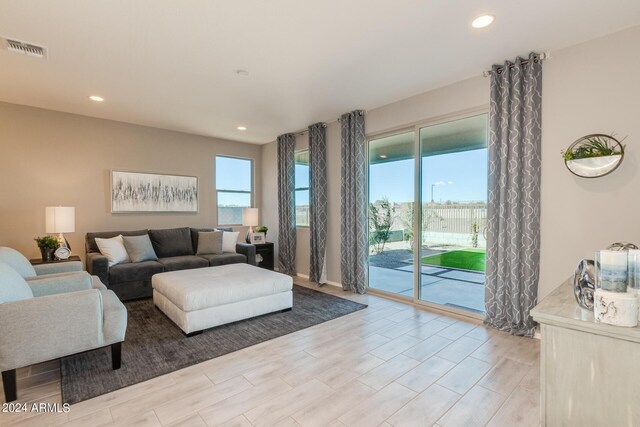 living room featuring wood tiled floor, visible vents, and recessed lighting