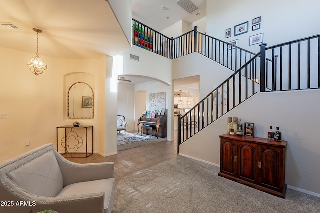 interior space with arched walkways, baseboards, stairs, and visible vents
