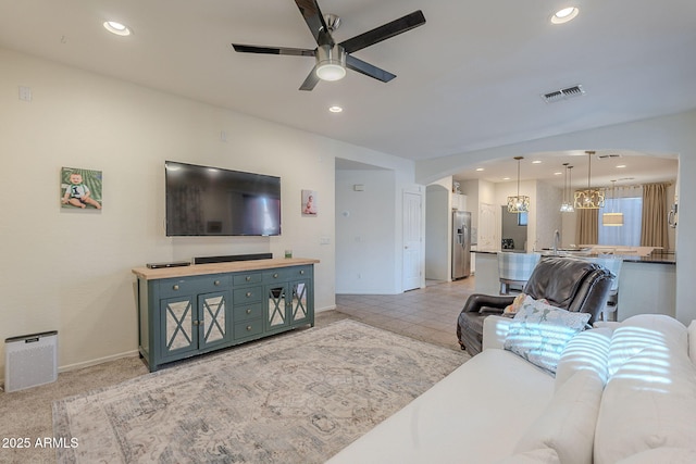 living area with visible vents, recessed lighting, baseboards, and ceiling fan with notable chandelier