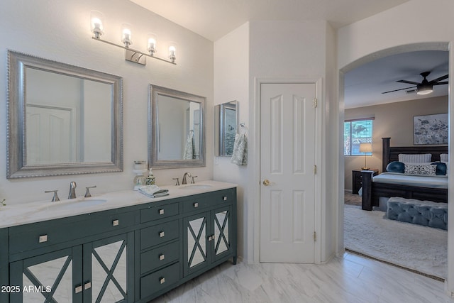 bathroom with double vanity, ceiling fan, a sink, and marble finish floor