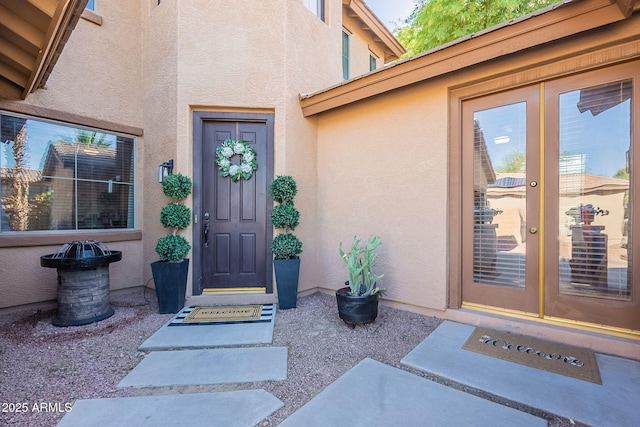 property entrance featuring stucco siding and french doors
