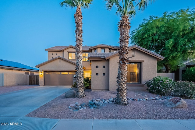 view of front of home featuring a garage, stucco siding, driveway, and fence