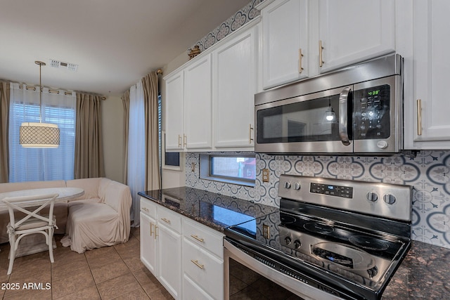 kitchen with visible vents, white cabinetry, dark stone countertops, appliances with stainless steel finishes, and light tile patterned floors