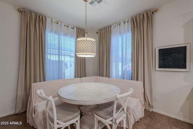 tiled dining area with baseboards and visible vents