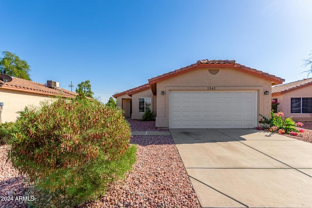 view of front of home featuring stucco siding, a garage, concrete driveway, and a tile roof