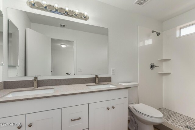 bathroom with a shower, tile patterned flooring, toilet, and vanity