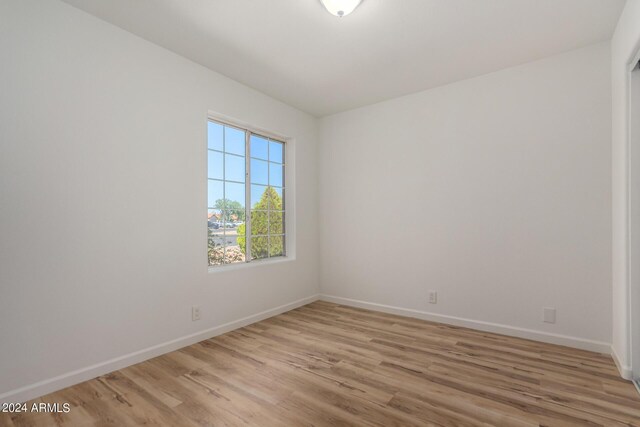 spare room with light wood-type flooring and baseboards
