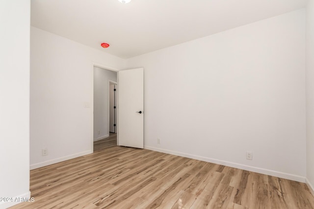unfurnished room with light wood-type flooring and baseboards