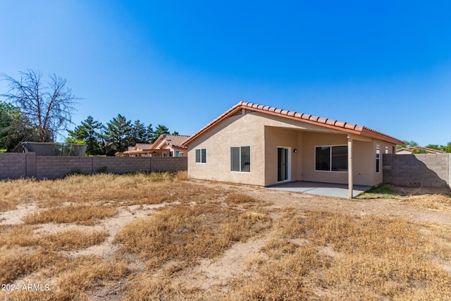 back of house featuring stucco siding, a patio, a fenced backyard, and a tiled roof