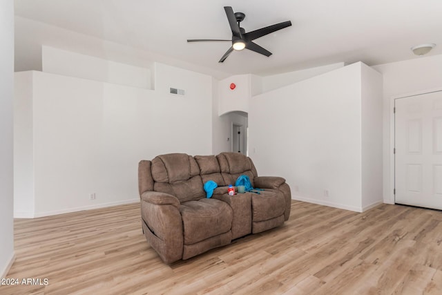 living area with a ceiling fan, visible vents, arched walkways, vaulted ceiling, and light wood-type flooring