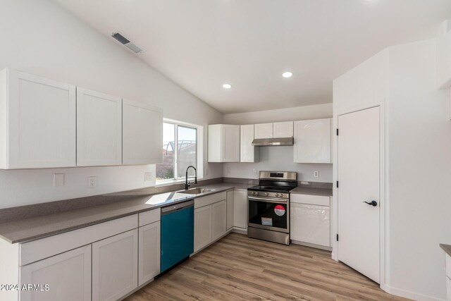 kitchen featuring light wood-type flooring, white cabinetry, stainless steel appliances, sink, and lofted ceiling