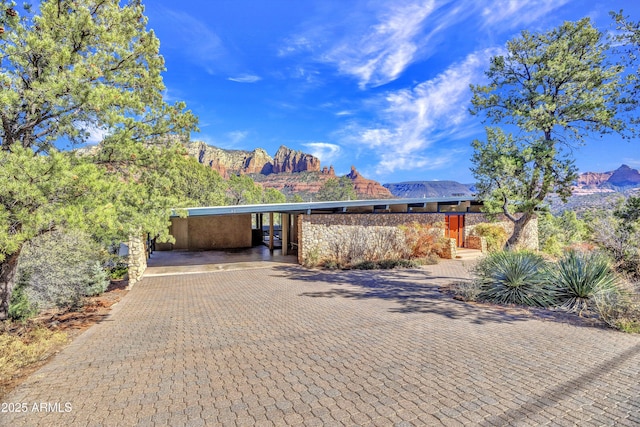 mid-century modern home with decorative driveway and a mountain view