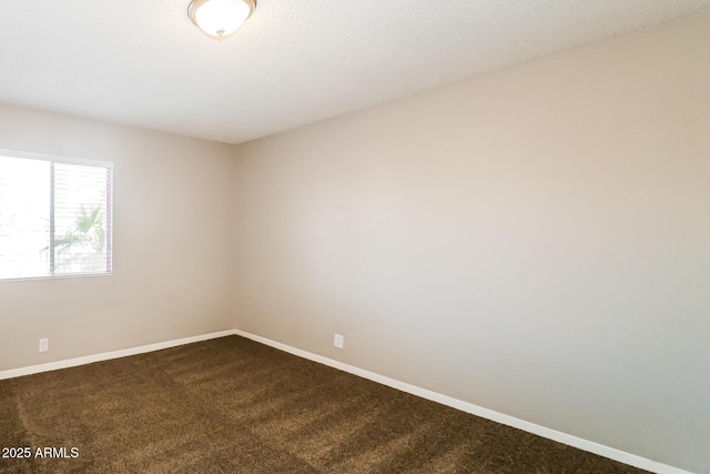 carpeted empty room featuring baseboards