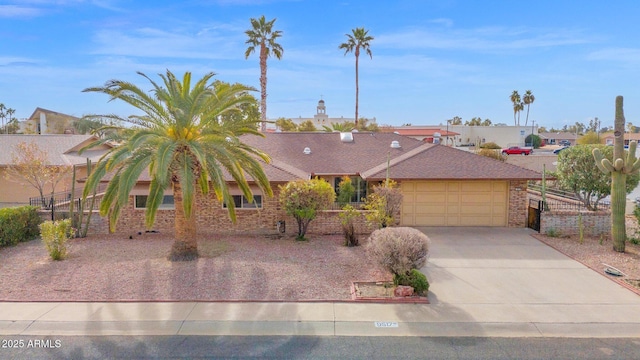 view of front of property with concrete driveway, brick siding, fence, and an attached garage