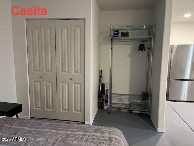 bedroom with freestanding refrigerator and a closet