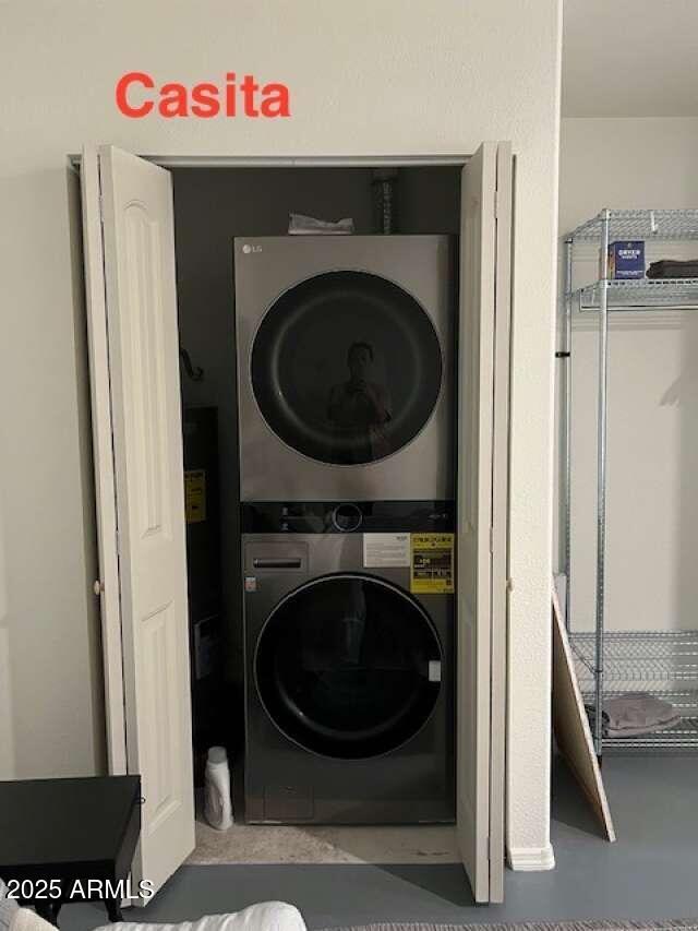 clothes washing area with laundry area and stacked washer / drying machine