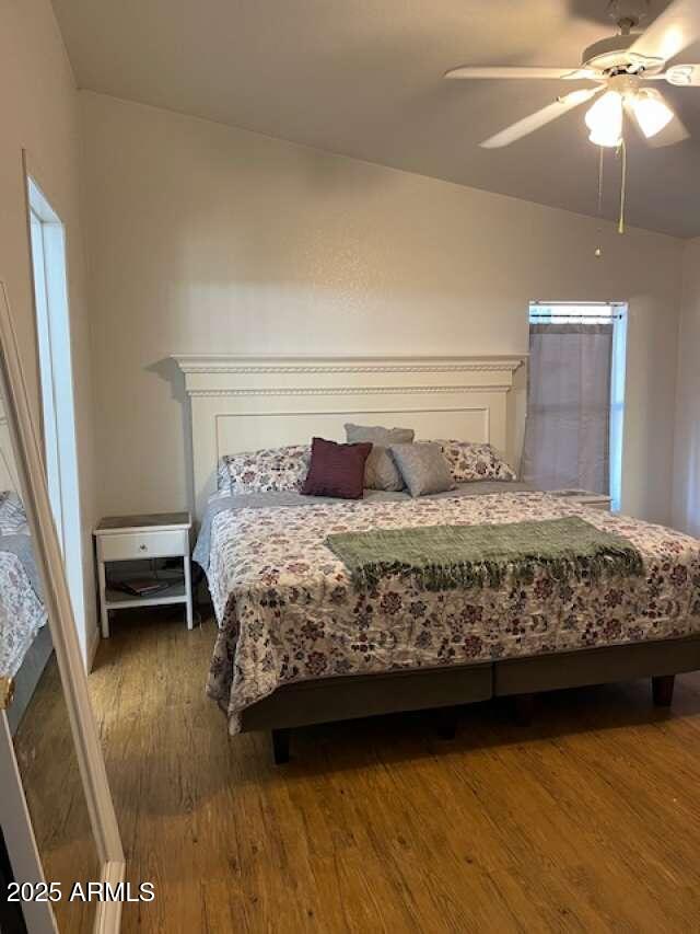 bedroom featuring lofted ceiling, ceiling fan, and dark wood-type flooring