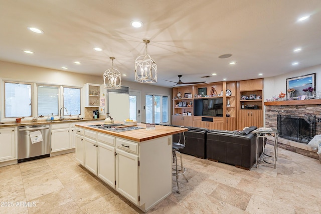 kitchen featuring decorative light fixtures, a center island, a kitchen breakfast bar, stainless steel appliances, and white cabinets