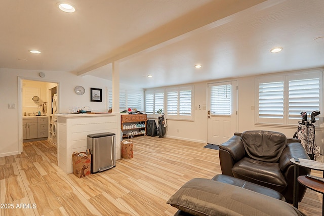 living room with vaulted ceiling with beams and light hardwood / wood-style floors