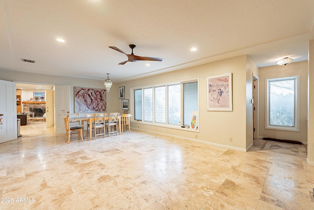 interior space featuring ceiling fan, a healthy amount of sunlight, and a fireplace