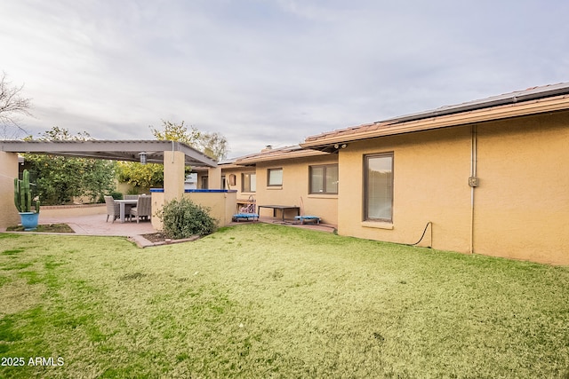 rear view of house featuring a patio area and a lawn