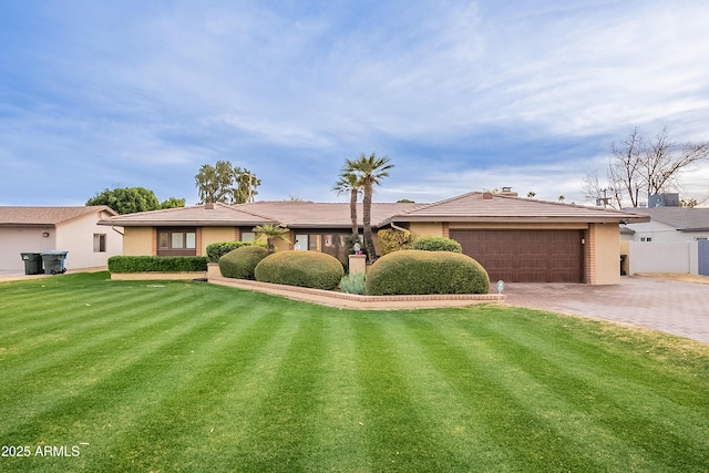 single story home featuring a garage and a front yard