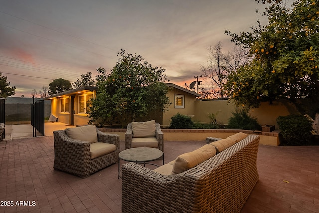 patio terrace at dusk featuring an outdoor living space