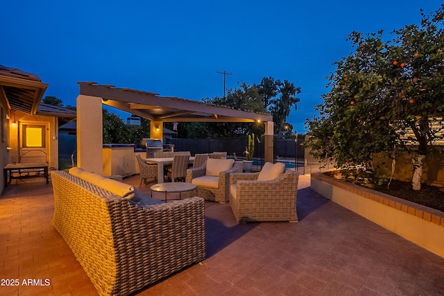 patio terrace at dusk featuring area for grilling, a grill, and an outdoor hangout area