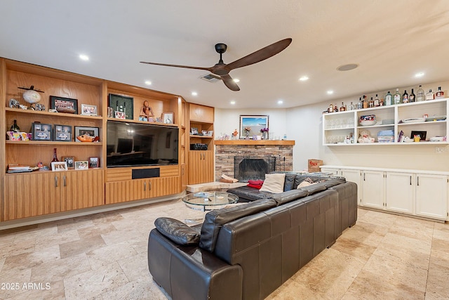 living room with ceiling fan and a fireplace