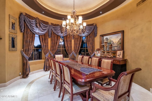 dining space featuring a tray ceiling, a towering ceiling, and a chandelier