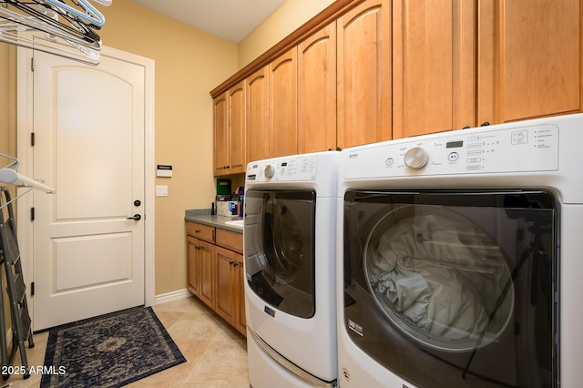 washroom featuring separate washer and dryer, light tile patterned floors, and cabinets