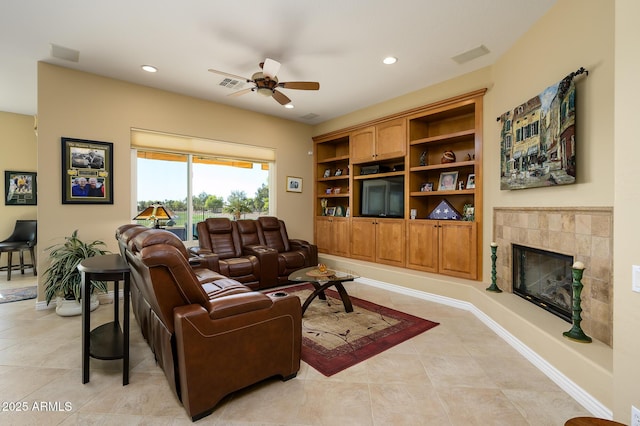 tiled living room featuring a tile fireplace, ceiling fan, and built in features