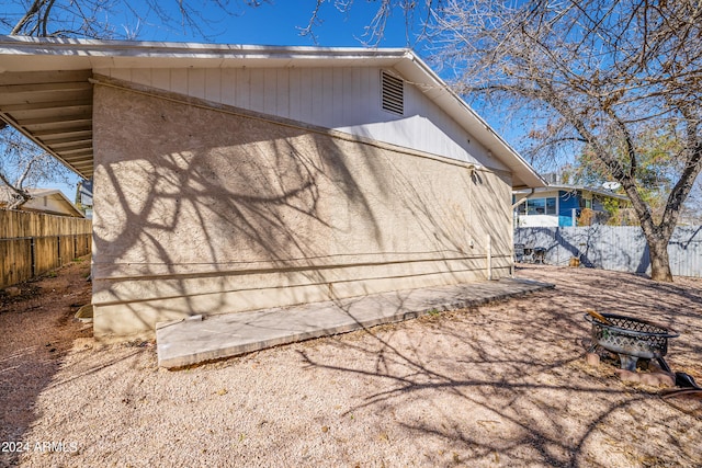 view of home's exterior with a fire pit and a patio area