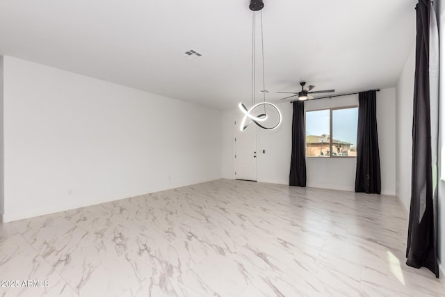 spare room featuring marble finish floor, ceiling fan, and visible vents