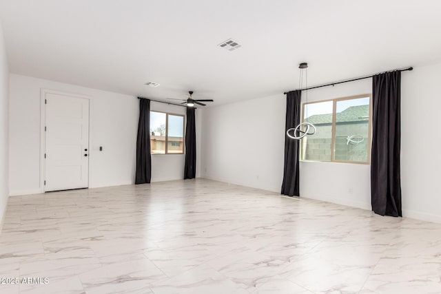 spare room with ceiling fan, marble finish floor, and visible vents