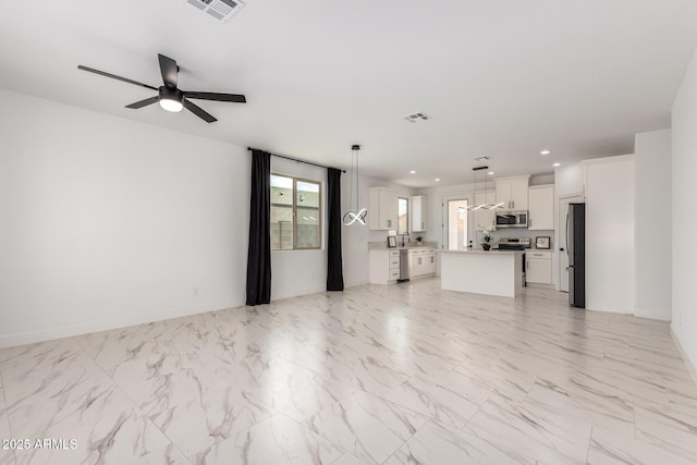 unfurnished living room with baseboards, visible vents, ceiling fan, and recessed lighting