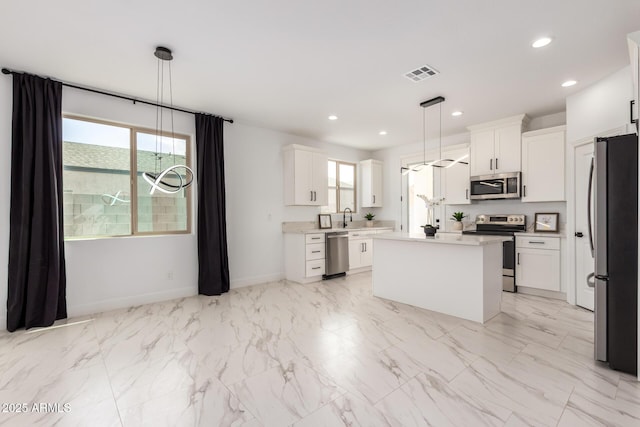 kitchen with appliances with stainless steel finishes, a wealth of natural light, a center island, and recessed lighting