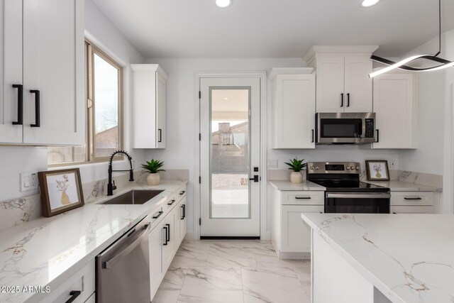 kitchen featuring recessed lighting, a sink, white cabinets, marble finish floor, and appliances with stainless steel finishes