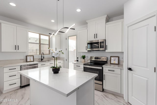 kitchen featuring marble finish floor, stainless steel appliances, recessed lighting, a sink, and a kitchen island