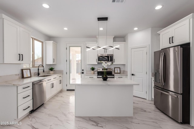 kitchen featuring a kitchen island, appliances with stainless steel finishes, marble finish floor, a sink, and recessed lighting