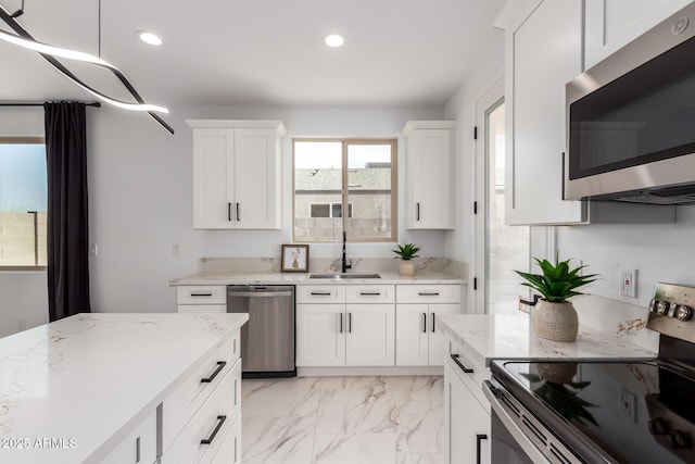 kitchen featuring marble finish floor, appliances with stainless steel finishes, a sink, and recessed lighting