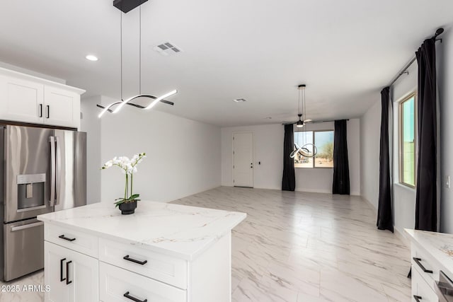 kitchen with marble finish floor, light stone counters, stainless steel refrigerator with ice dispenser, and pendant lighting