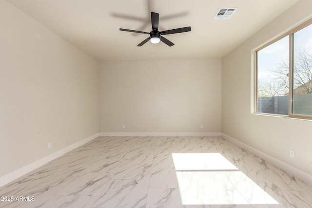 empty room featuring marble finish floor, visible vents, and baseboards