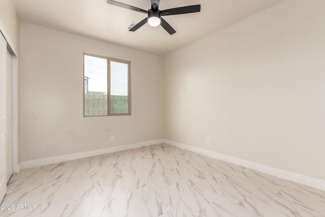 unfurnished bedroom with a closet, ceiling fan, marble finish floor, and baseboards